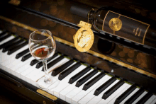 a piano with a bottle of wine and a glass of wine on it