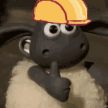 a sheep wearing a yellow hard hat is giving a thumbs up .