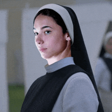 a woman wearing a nun 's veil is looking at the camera