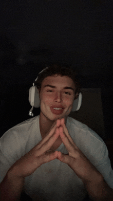 a young man wearing headphones is making a peace sign with his hands