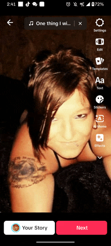 a woman with a tattoo on her arm is laying on a bed in a selfie app