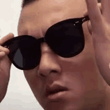 a close up of a man wearing sunglasses and making a funny face .