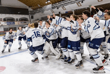 a group of hockey players are celebrating a win and one of them has the number 16 on his shirt