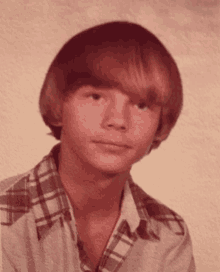 a young man with red hair and a plaid shirt