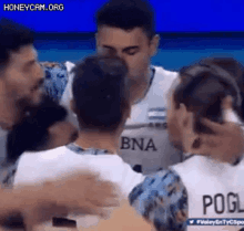 a group of volleyball players are hugging each other and celebrating a win .