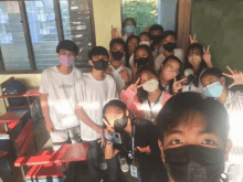 a group of young people wearing face masks pose for a picture with one wearing a white shirt that says orgn