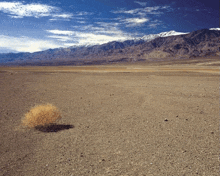 a barren desert landscape with mountains in the background