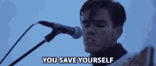 a man singing into a microphone with the words " you save yourself " next to him