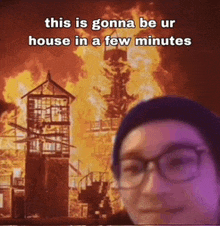 a man wearing glasses is standing in front of a burning house with a caption that says this is gonna be ur house