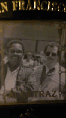 a black and white photo of two men in front of a sign that says " san francisco "