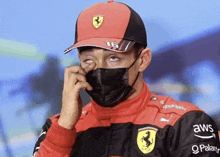 a man wearing a ferrari hat and a black mask