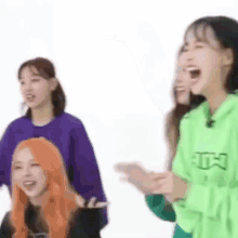 a group of girls are laughing and clapping while standing next to each other on a white background .