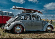 a grey car with a surfboard on top of it