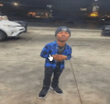 a man wearing a plaid shirt and a beanie is standing in front of a car