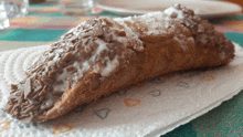 a pastry with chocolate sprinkles and powdered sugar on a napkin