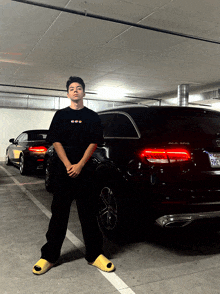 a man is standing in front of a black mercedes benz