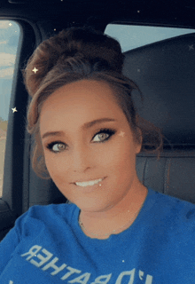 a woman wearing a blue shirt that says ' ashtag ' on it smiles for the camera