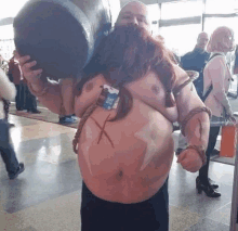 a man with a beard is wearing a costume and holding a large barrel on his shoulders .