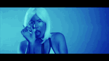 a woman in a white wig is making a funny face in a blue light