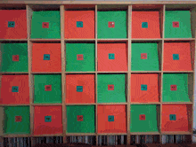 a shelf full of red and green boxes with numbers on them including the number 12