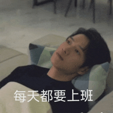 a man in a black shirt is laying on a bed with chinese writing on the bottom