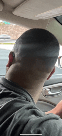 the back of a man 's head is shown while driving