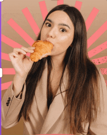 a woman is eating a croissant with a pink and brown background