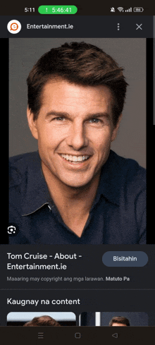 a phone screen shows a picture of tom cruise smiling