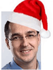 a man wearing glasses and a santa hat is smiling