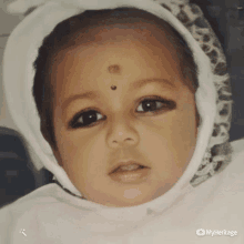 a close up of a baby 's face with a myheritage logo on the bottom