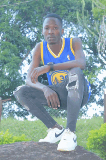 a young man wearing a golden state warriors jersey