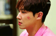 a close up of a man 's face with kbs2 written on the bottom left