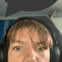 a close up of a person wearing headphones with a speech bubble above their head