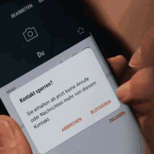 a person is holding a cell phone with a screen that says kontakt sperren on it