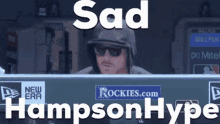 a man wearing a helmet and sunglasses is sitting in the dugout with the words sad hampton hype written on the bottom