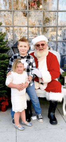 three children pose for a picture with santa