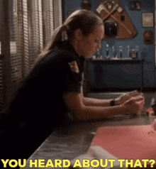 a woman in a police uniform sits at a desk with the words " you heard about that " behind her