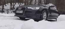 a black audi is parked in the snow with a license plate that says ' ec ' on it