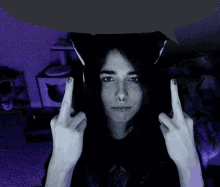 a woman wearing a cat ear headband giving the middle finger