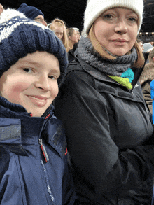 a boy and a woman wearing hats and scarves