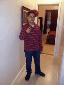 a young boy wearing a red striped shirt and a red hat