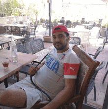 a man is sitting in a chair wearing a italia shirt