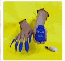 a person with long blue nails is holding a bottle of lotion