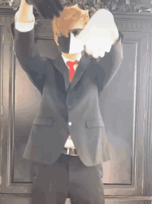 a man in a suit and tie is dancing with his arms in the air