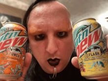 a man holding two cans of mtn dew in his hands