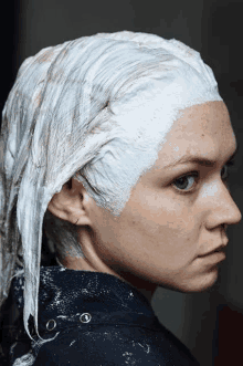 a woman is getting her hair dyed with bleach