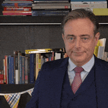 a man in a suit and tie is standing in front of a bookshelf with a book called academia on it