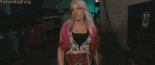 a woman with blonde hair and pink highlights is holding a championship belt .