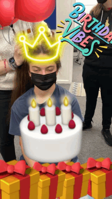 a girl wearing a black mask holds a birthday cake