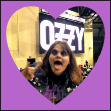 a woman stands in front of a large sign that says ozzy on it